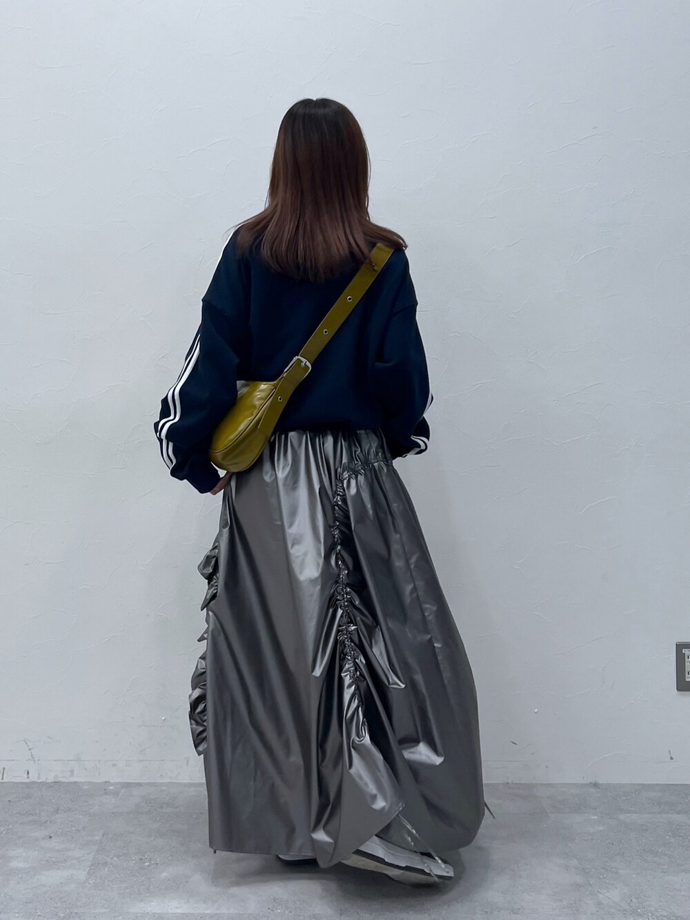 シルバー系のスカート、ブルー系のスウェットを着用したレディースの冬コーディネートの3枚目の写真