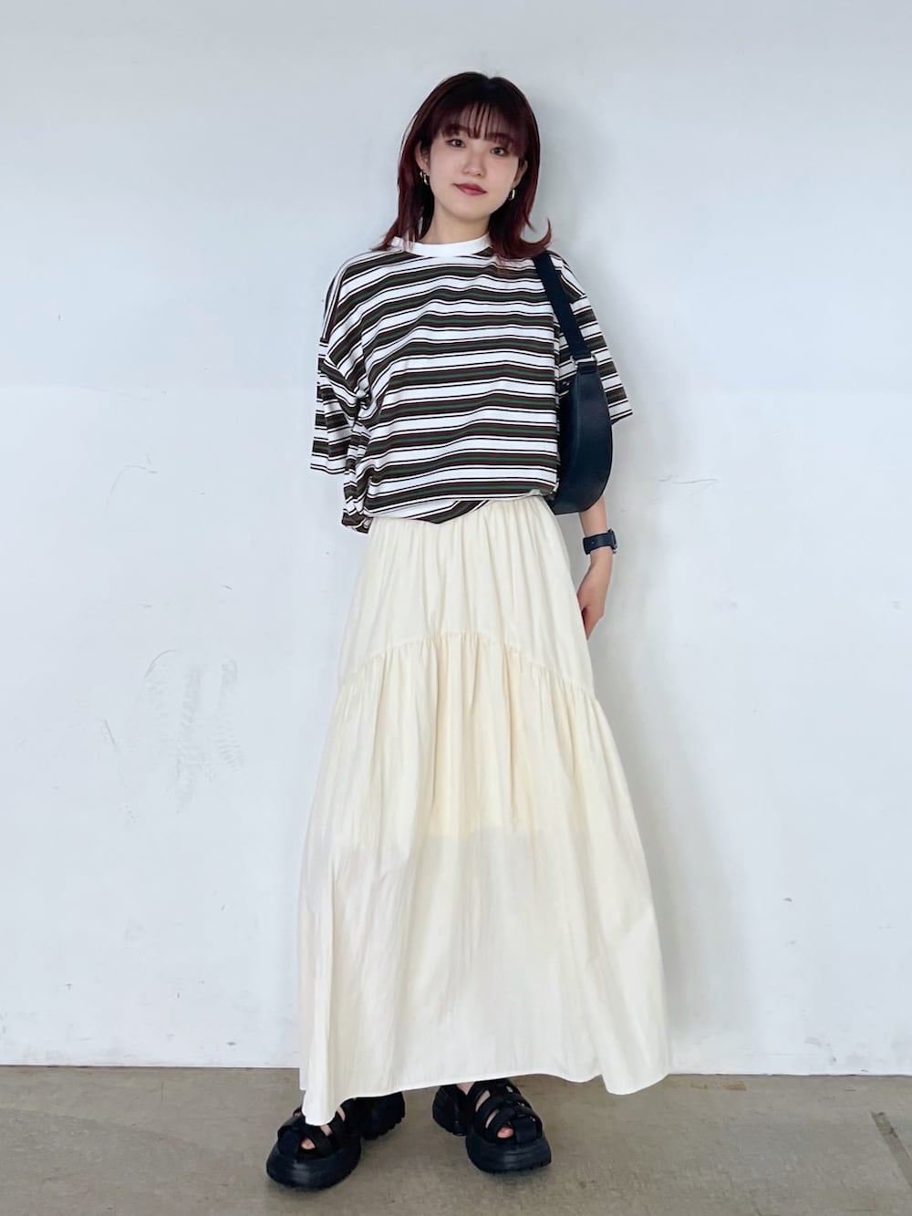 ブラック系のショルダーバッグ、ホワイト系のTシャツ/カットソー、ブラック系のサンダルを着用したレディースの春コーディネートの4枚目の写真