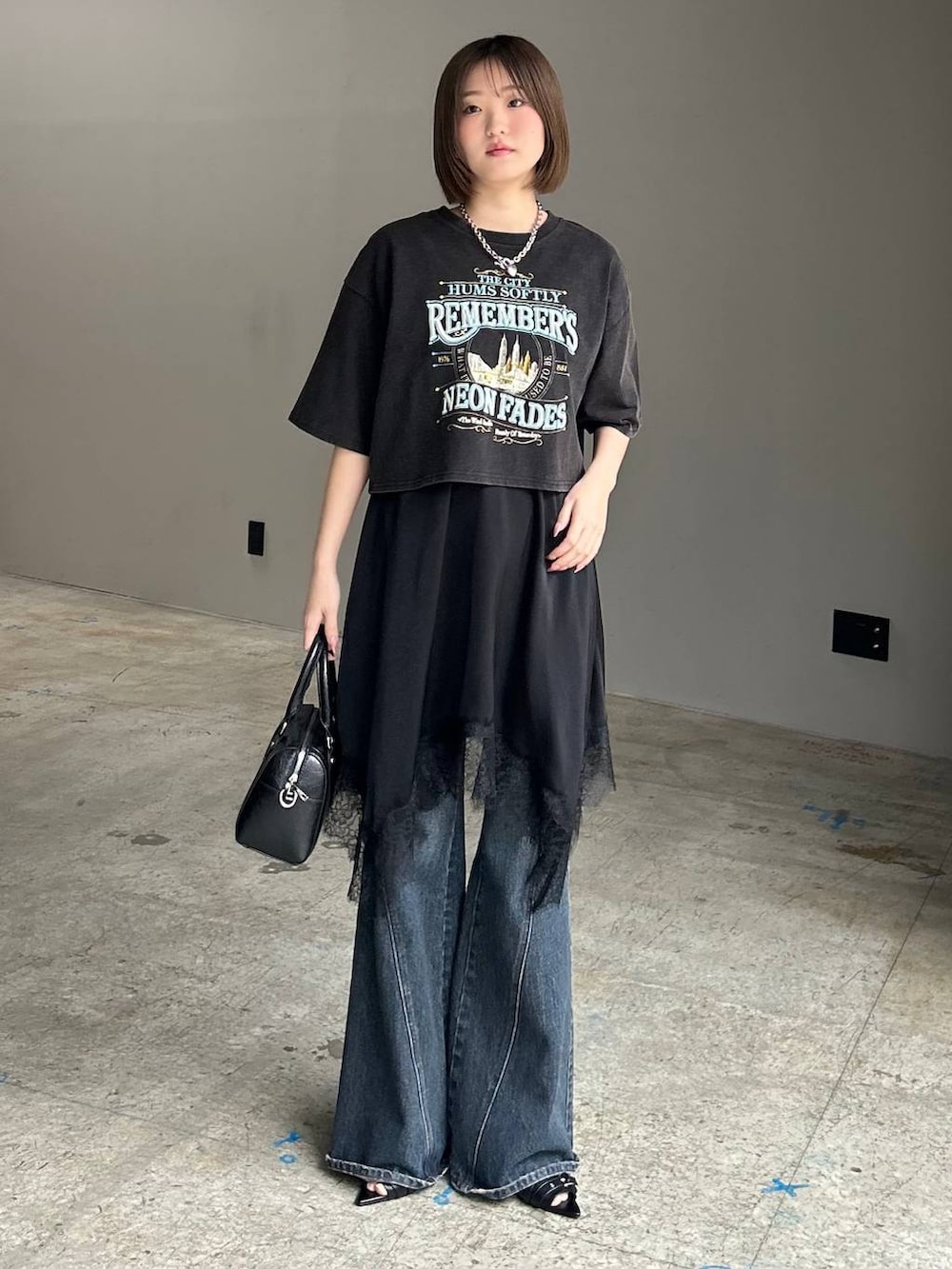 ブルー系のデニムパンツ、ブラック系のボストンバッグ、ブラック系のサンダルを着用したレディースの春コーディネートの2枚目の写真