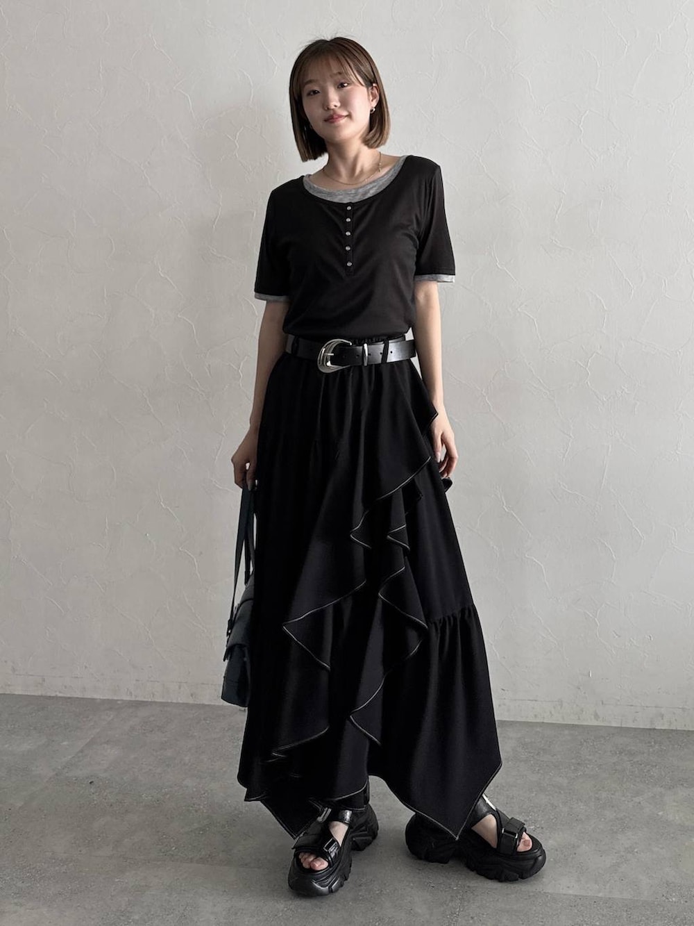 ブラック系のスカート、ブラック系のサンダル、ブラック系のTシャツ/カットソーを着用したレディースの夏コーディネートの5枚目の写真