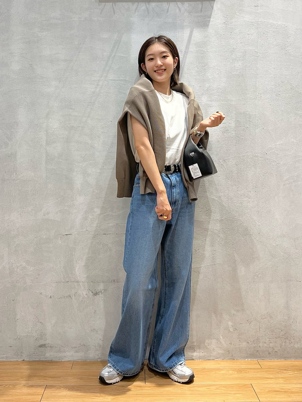 ブルー系のデニムパンツ、グレー系のスニーカー、ホワイト系のTシャツ/カットソーを着用したレディースの秋コーディネートの4枚目の写真