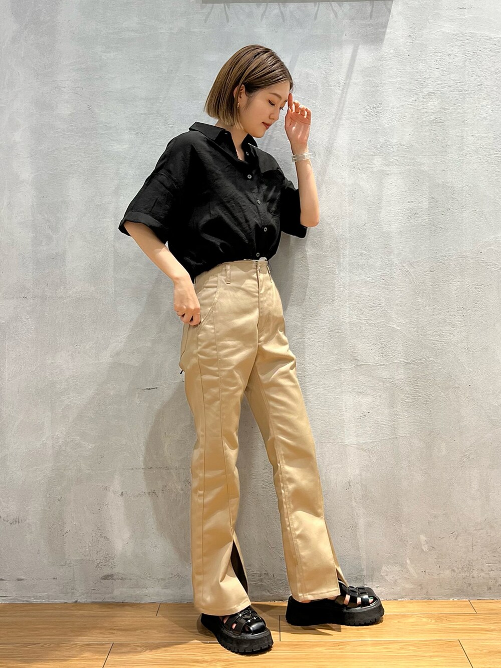 ブラック系のシャツ/ブラウス、ベージュ系のチノパンツ、ブラック系のサンダルを着用したレディースの夏コーディネートの2枚目の写真