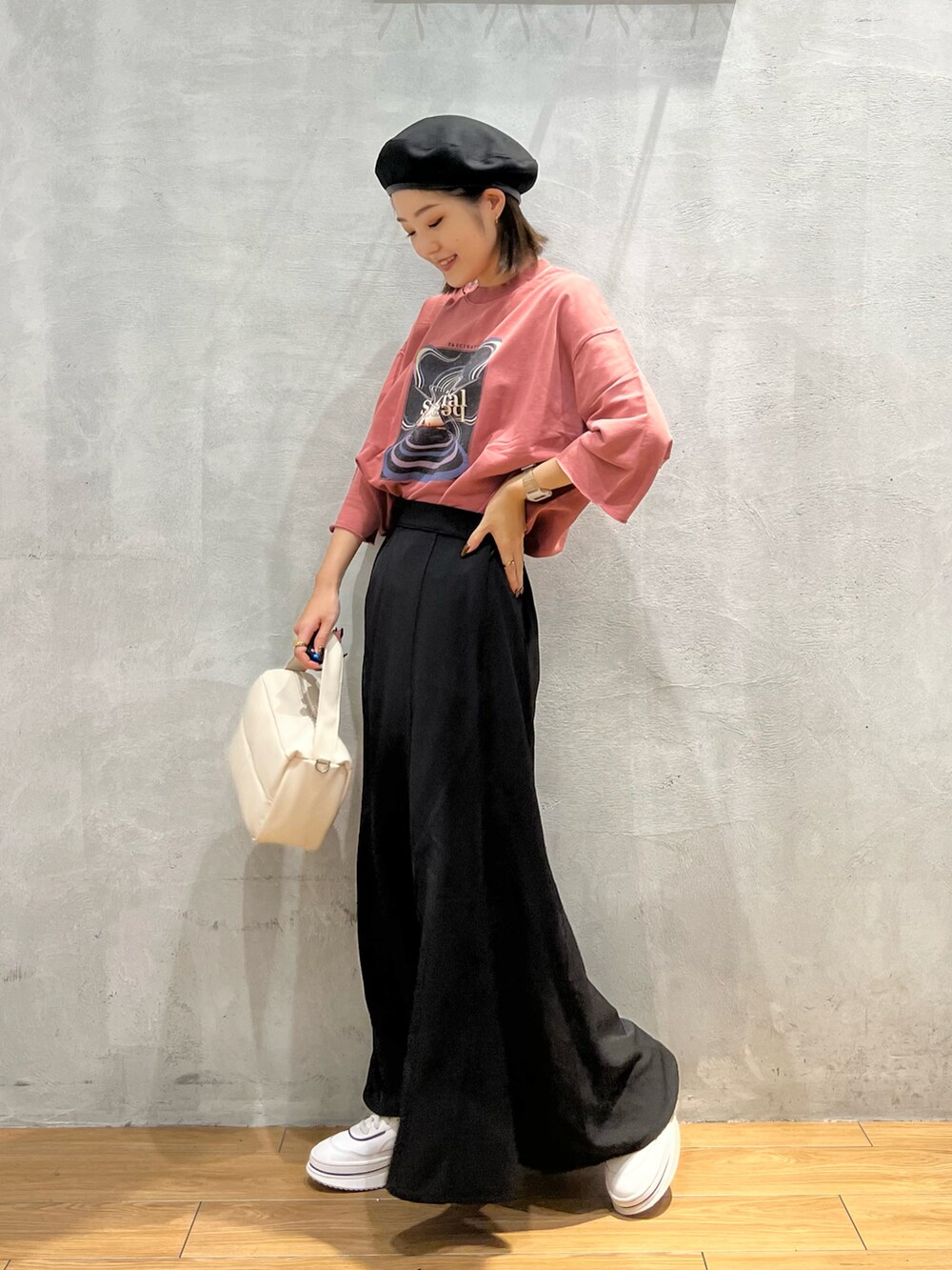 ピンク系のTシャツ/カットソー、ホワイト系のショルダーバッグ、ブラック系のスカートを着用したレディースの秋コーディネートの2枚目の写真