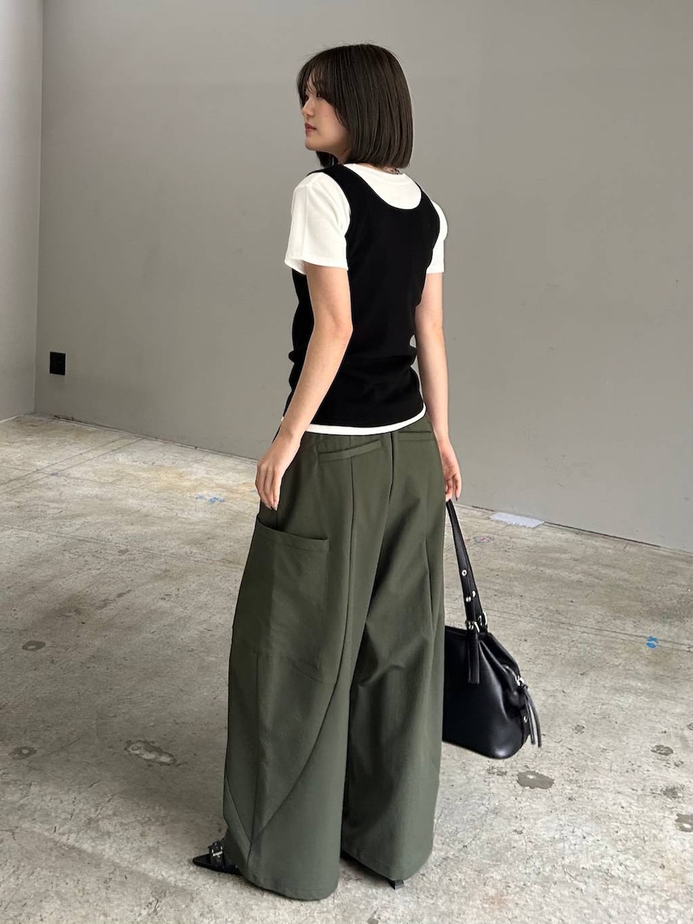 グリーン系のカーゴパンツ、ブラック系のサンダル、ブラック系のボストンバッグを着用したレディースの春コーディネートの4枚目の写真