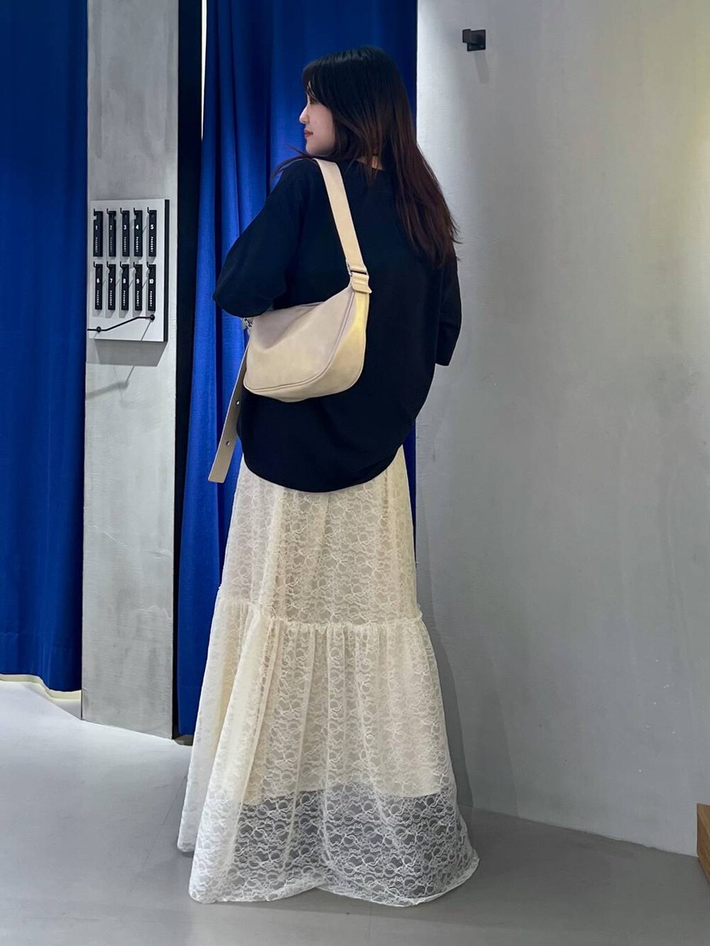 ブラック系のスニーカー、ベージュ系のショルダーバッグ、ブルー系のTシャツ/カットソーを着用したレディースの夏コーディネートの5枚目の写真
