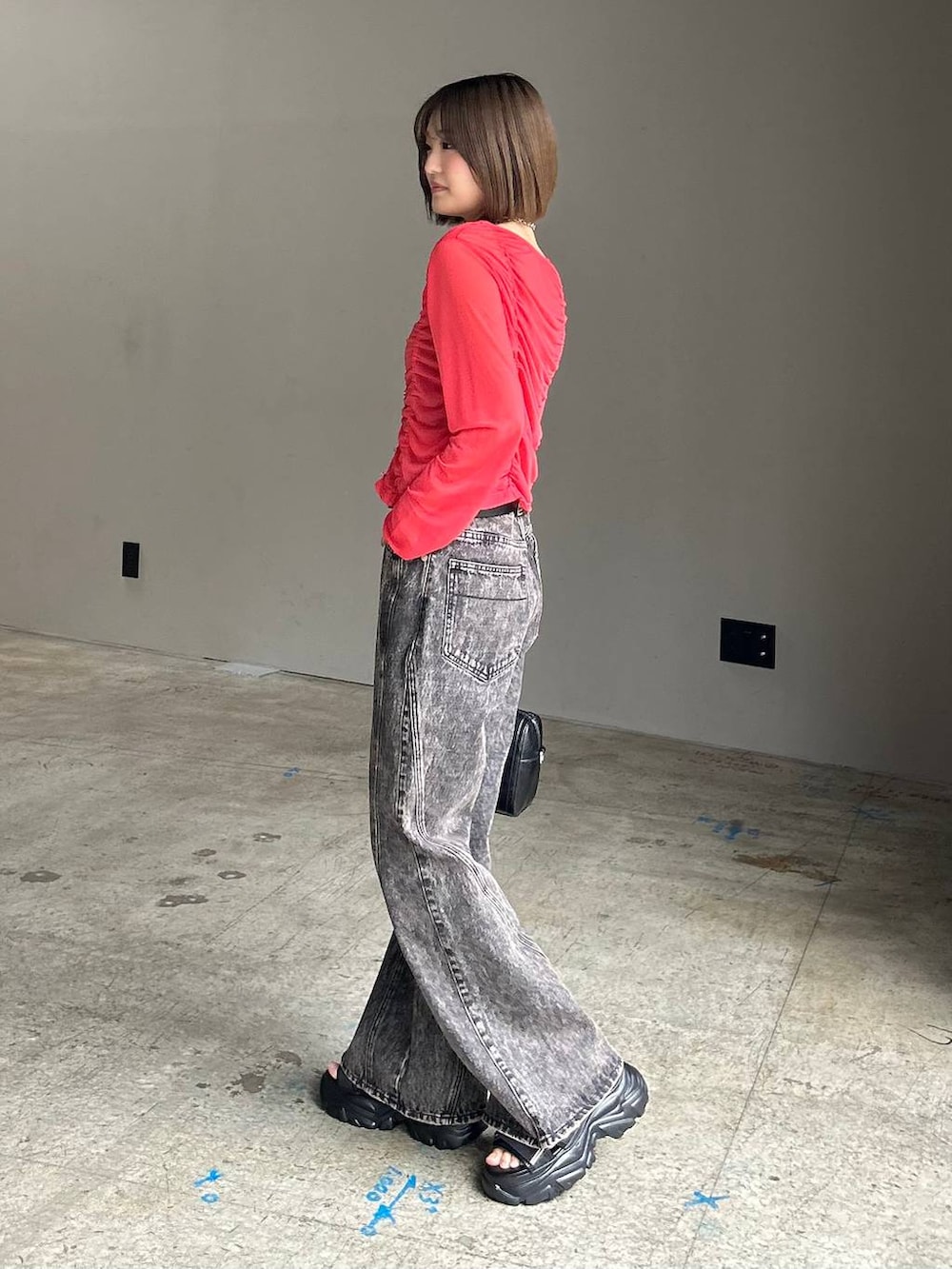 ブラック系のキャミソール、ブラック系のデニムパンツ、ブラック系のボストンバッグを着用したレディースの春コーディネートの5枚目の写真