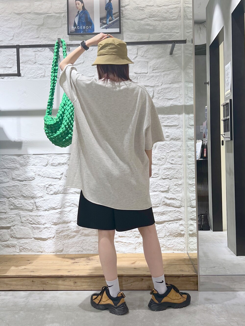 ベージュ系のTシャツ/カットソー、ブラック系のその他パンツ、ベージュ系のハットを着用したレディースの春コーディネートの3枚目の写真