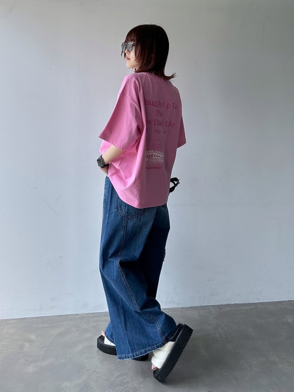 ピンク系のTシャツ/カットソー、ブルー系のデニムパンツ、ブラック系のショルダーバッグを着用したレディースの春コーディネートの2枚目の写真