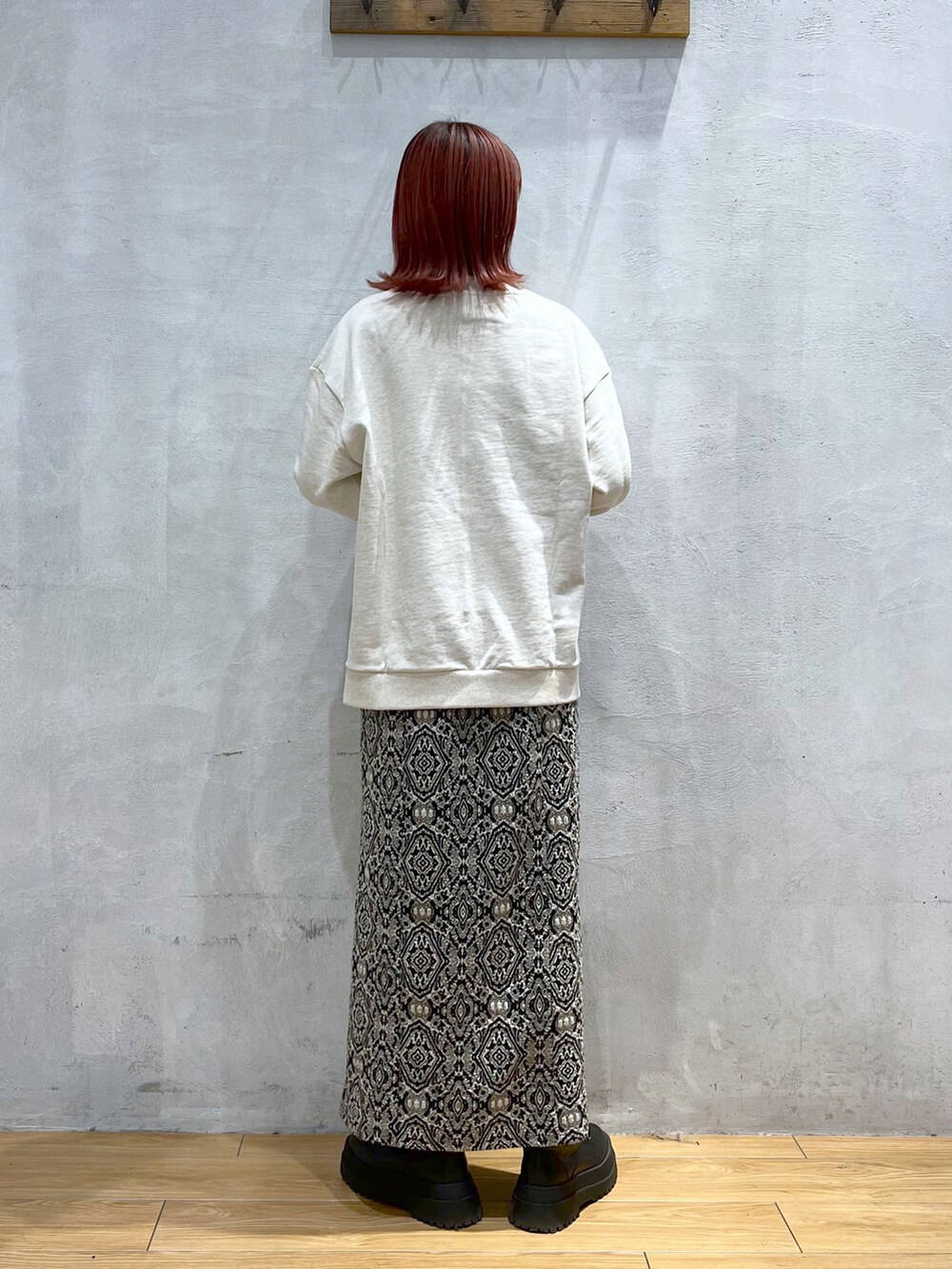 ブラック系のスカート、ベージュ系のスウェット、ブラック系のニット/セーターを着用したレディースの冬コーディネートの2枚目の写真