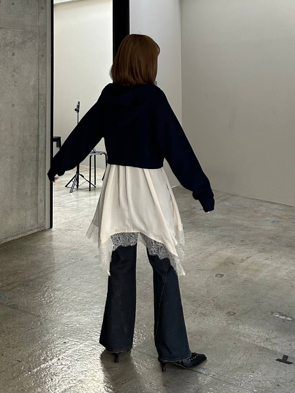 ブルー系のデニムパンツ、ブラック系のサンダル、ブルー系のパーカーを着用したレディースの冬コーディネートの3枚目の写真