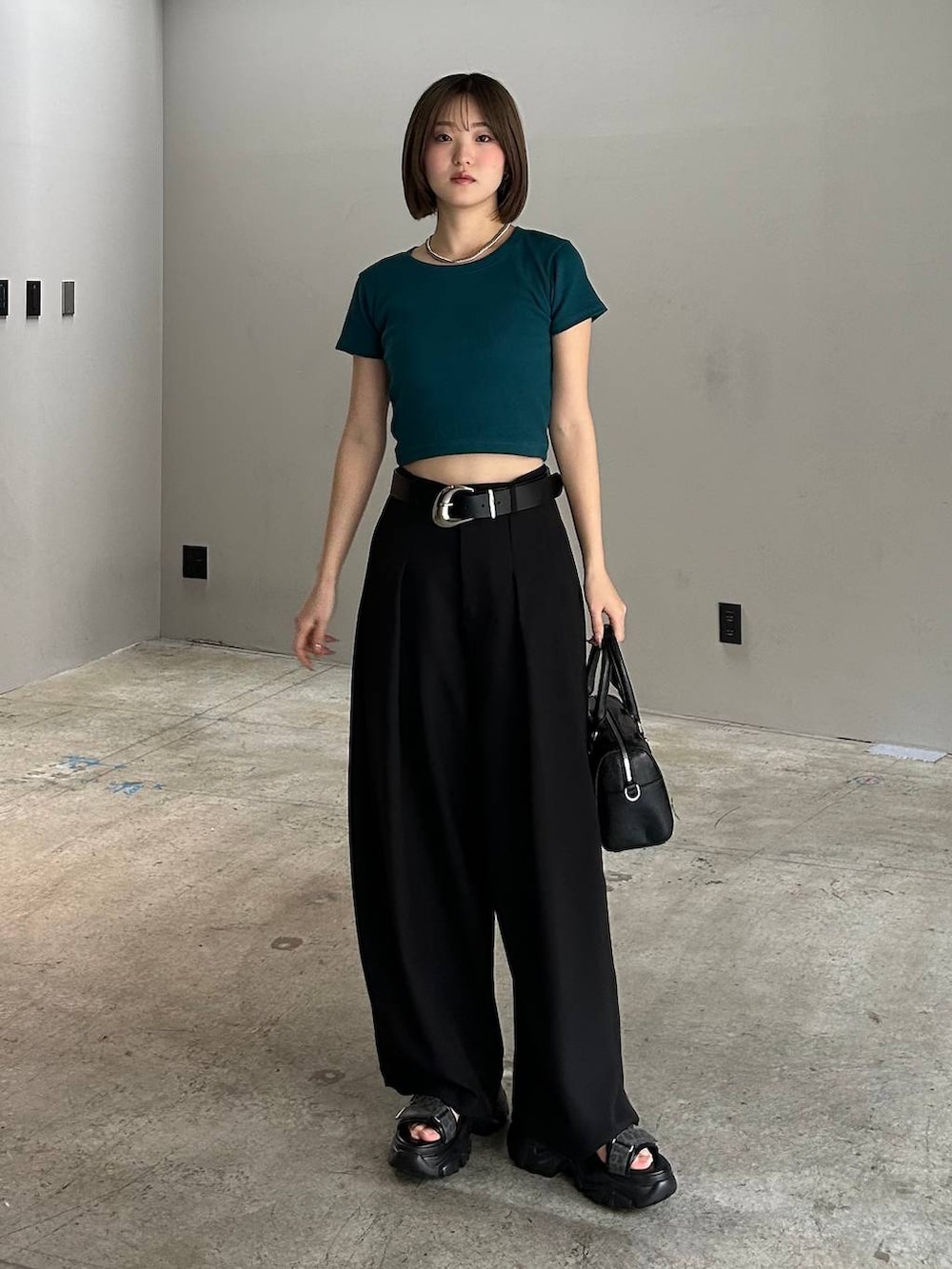 ブラック系のボストンバッグ、ブラック系のサンダル、ブラック系のスラックスを着用したレディースの春コーディネートの4枚目の写真