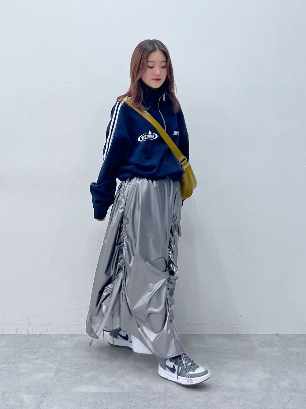 シルバー系のスカート、ブルー系のスウェットを着用したレディースの冬コーディネートの2枚目の写真