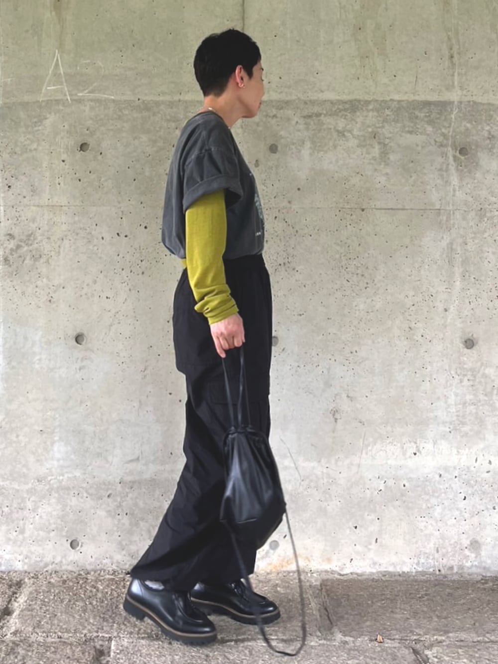 グレー系のTシャツ/カットソー、ブラック系のドレスシューズ、ブラック系のショルダーバッグを着用したレディースの春コーディネートの2枚目の写真