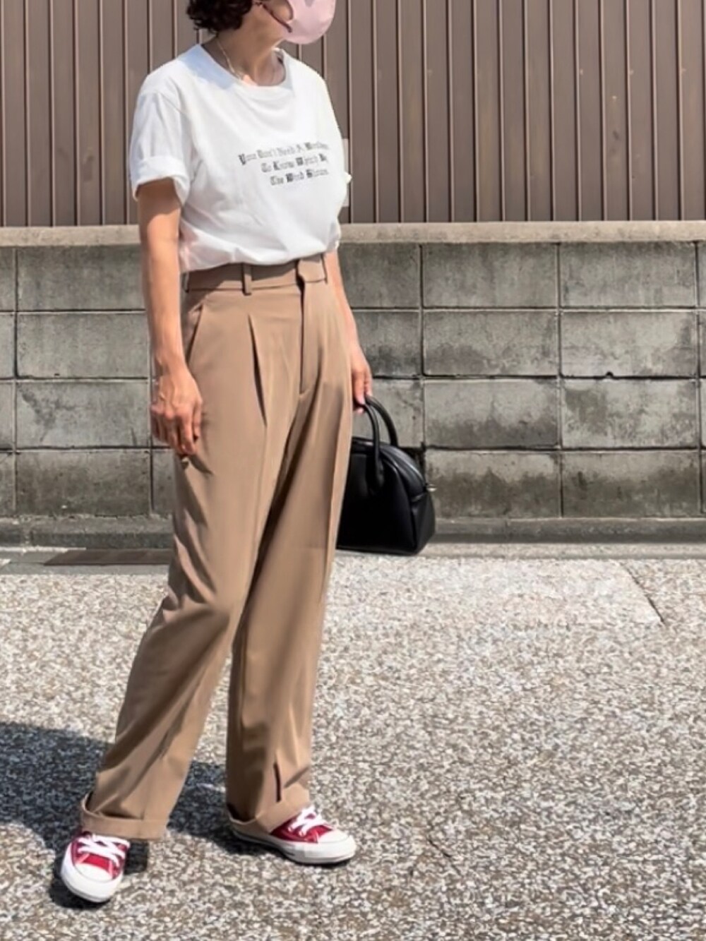 ベージュ系のパンツ、ホワイト系のTシャツ/カットソー、ブラック系のボストンバッグを着用したレディースの夏コーディネートの2枚目の写真