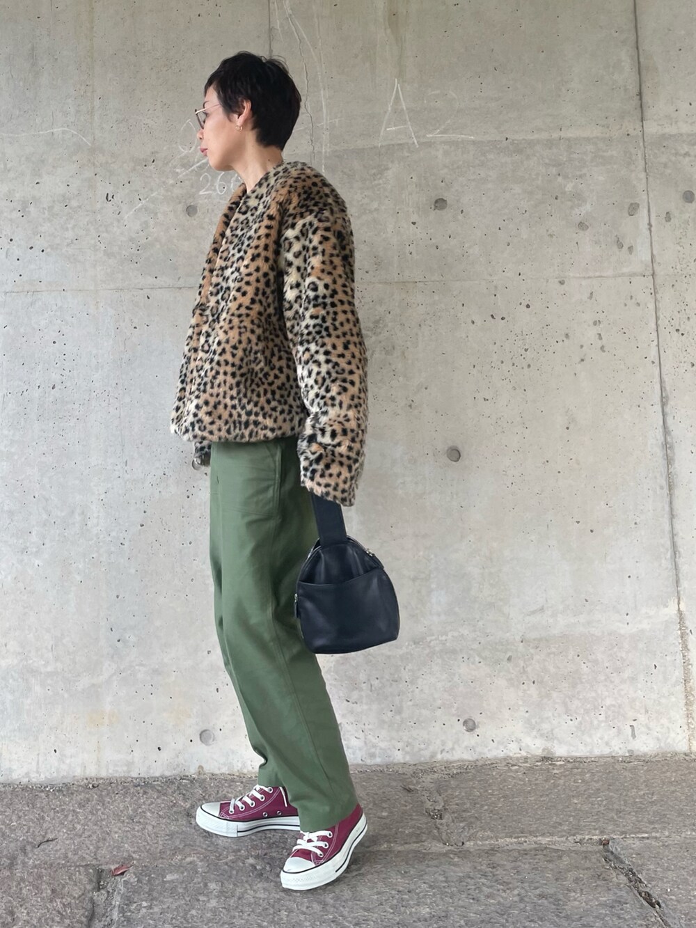 グリーン系のその他パンツ、レッド系のスニーカー、ブラック系のハンドバッグを着用したレディースの冬コーディネートの3枚目の写真