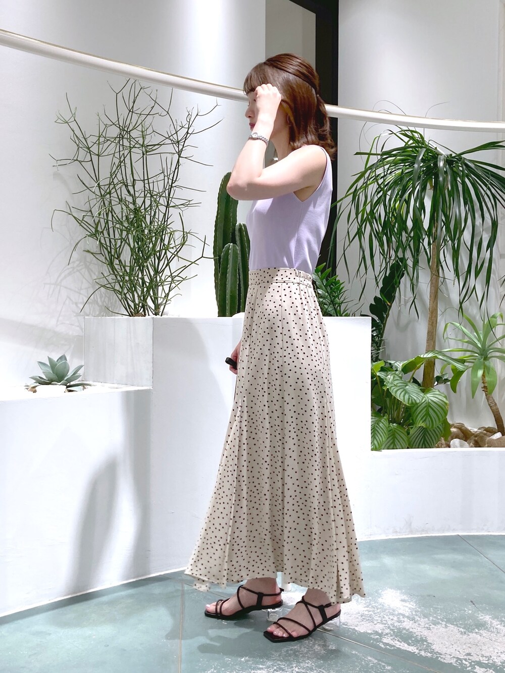 パープル系のニット/セーター、ベージュ系のスカート、ベージュ系のショルダーバッグを着用したレディースの春コーディネートの3枚目の写真