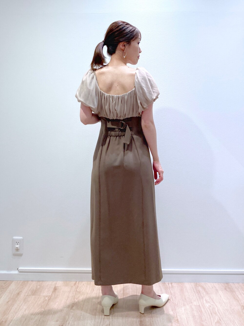 ベージュ系のドレス、ホワイト系のパンプスを着用したレディースの夏コーディネートの2枚目の写真