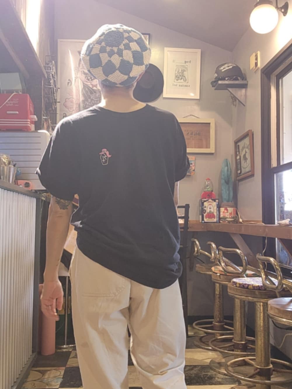 ブラック系のTシャツ/カットソー、ホワイト系のチノパンツ、ブルー系のハンチング/ベレー帽を着用したレディースの夏コーディネートの3枚目の写真