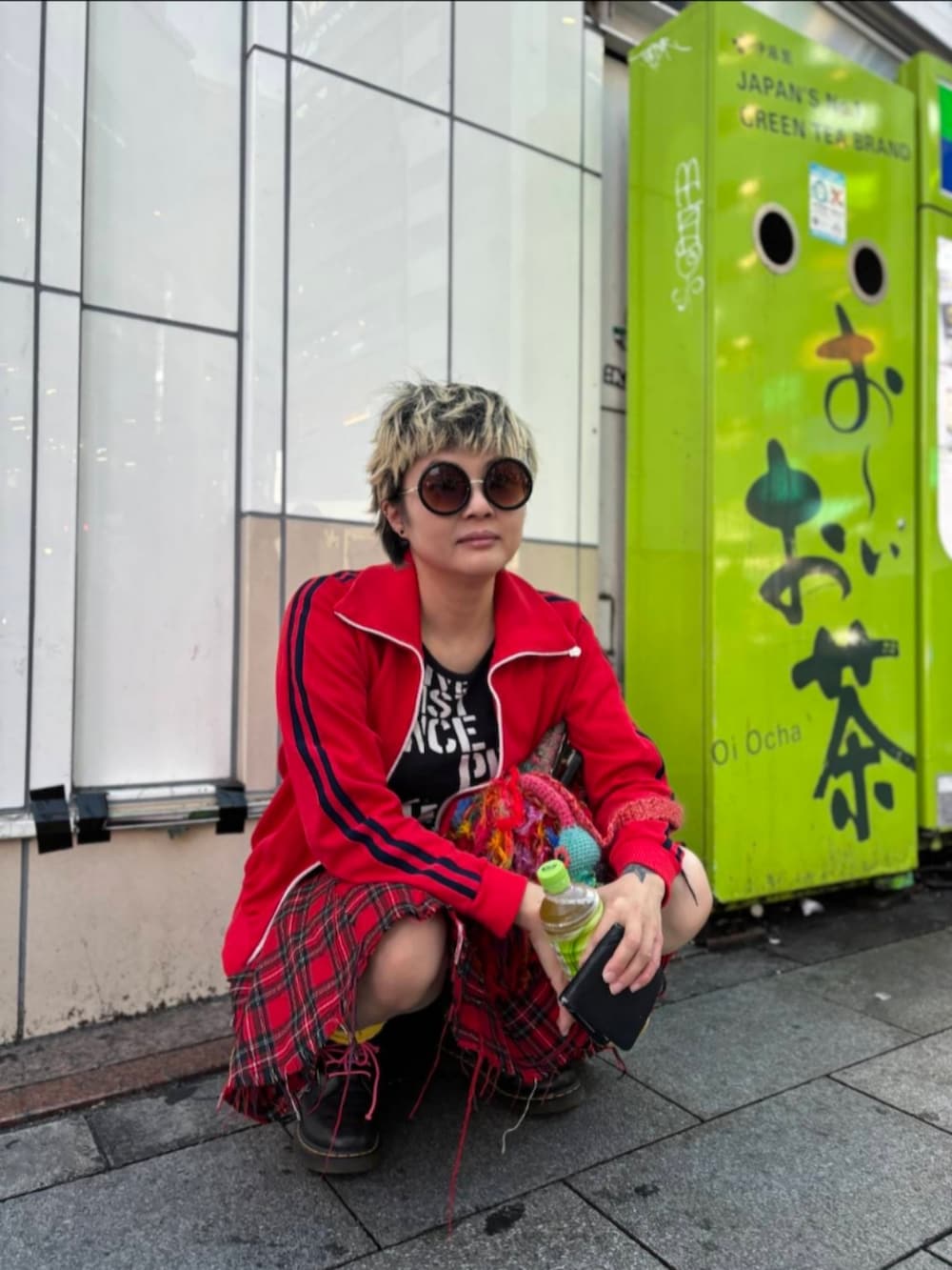 レッド系のスカート、ブラック系のブーツ、ブラック系のTシャツ/カットソーを着用したレディースの秋コーディネートの2枚目の写真