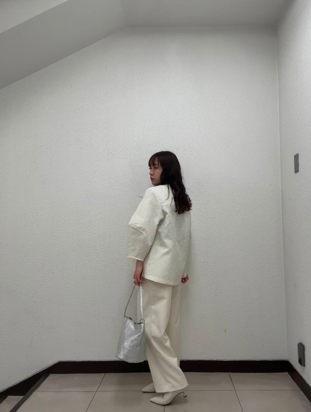 シルバー系のハンドバッグ、ホワイト系のその他パンツ、イエロー系のその他アウターを着用したレディースの冬コーディネートの5枚目の写真