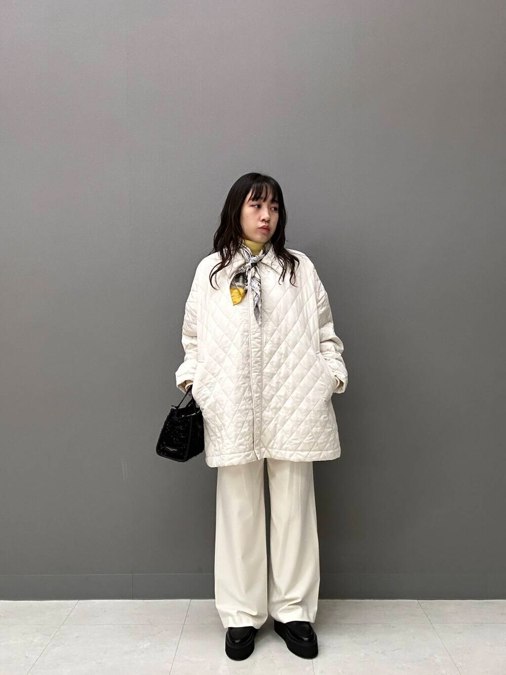 ホワイト系のダウンジャケット/コート、ホワイト系のその他パンツ、ブラック系のハンドバッグを着用したレディースの秋コーディネートの2枚目の写真
