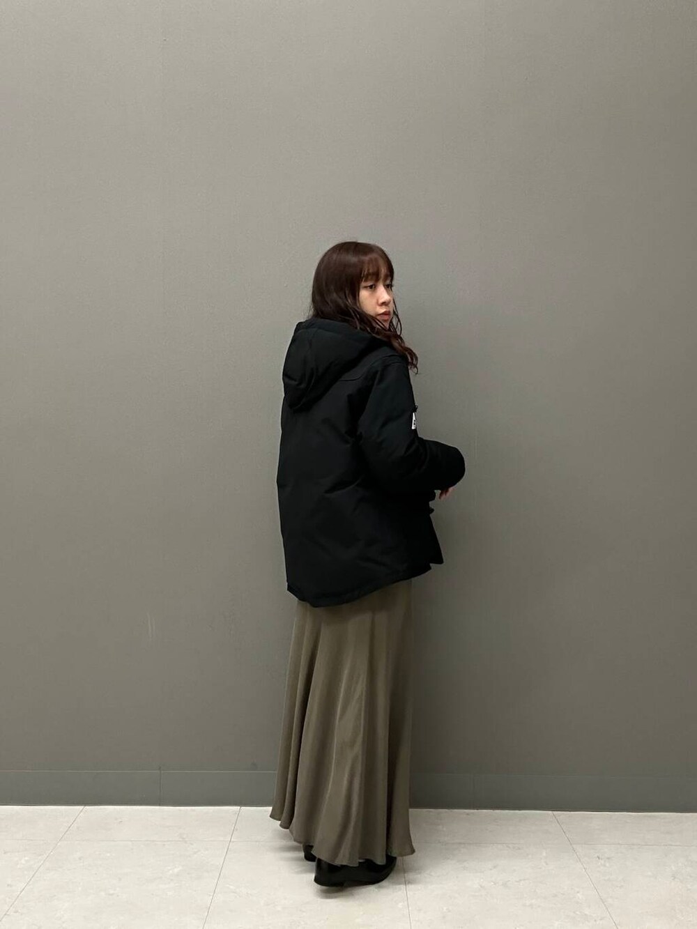 ブラック系のドレスシューズ、グリーン系のスカート、ホワイト系のシャツ/ブラウスを着用したレディースの冬コーディネートの2枚目の写真