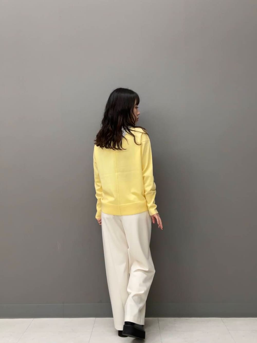 ホワイト系のダウンジャケット/コート、ホワイト系のその他パンツ、ブラック系のハンドバッグを着用したレディースの秋コーディネートの6枚目の写真