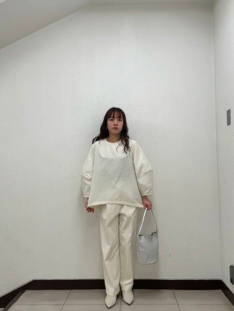 シルバー系のハンドバッグ、ホワイト系のその他パンツ、イエロー系のその他アウターを着用したレディースの冬コーディネートの4枚目の写真