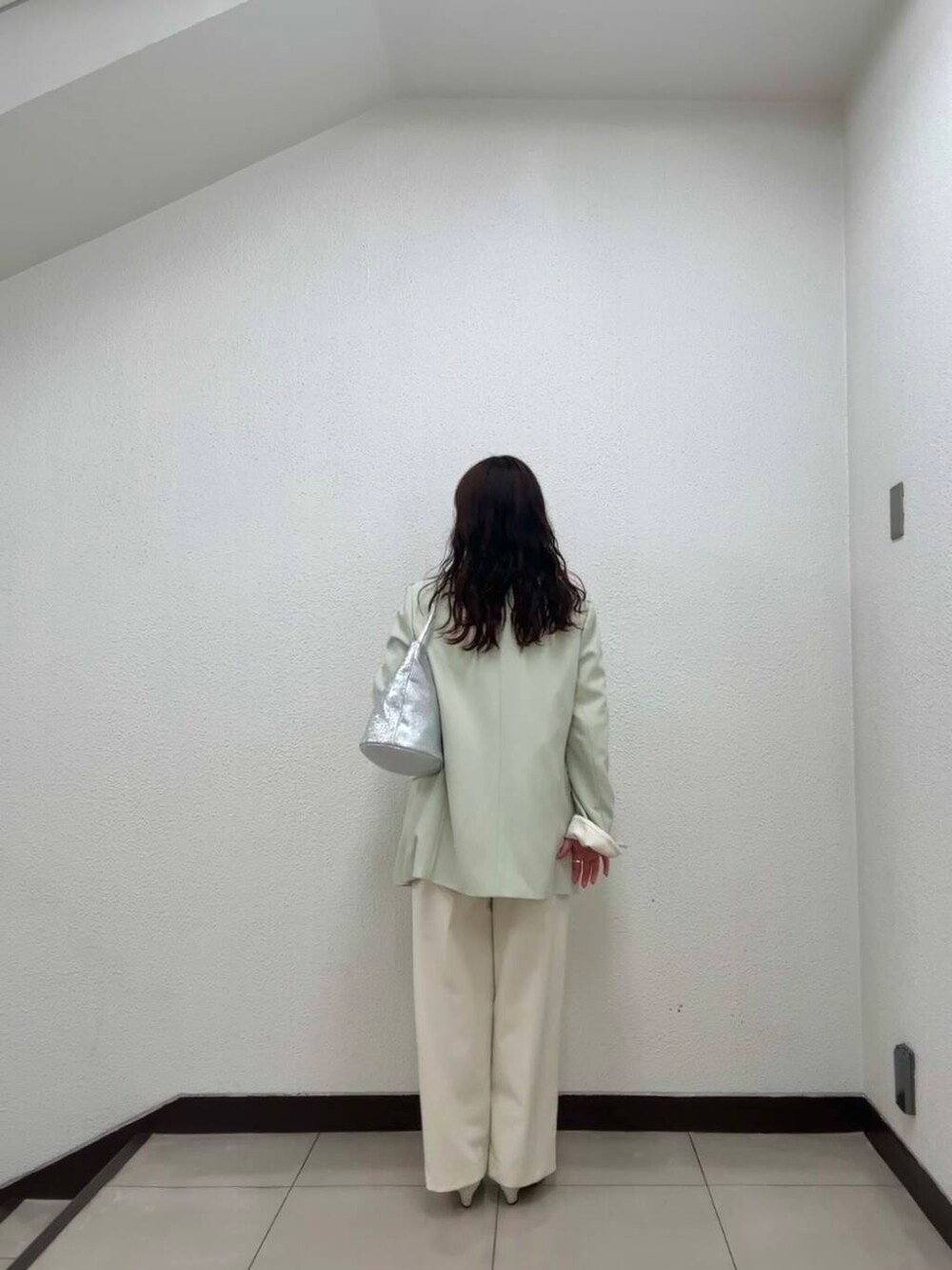 シルバー系のハンドバッグ、ホワイト系のその他パンツ、イエロー系のその他アウターを着用したレディースの冬コーディネートの2枚目の写真