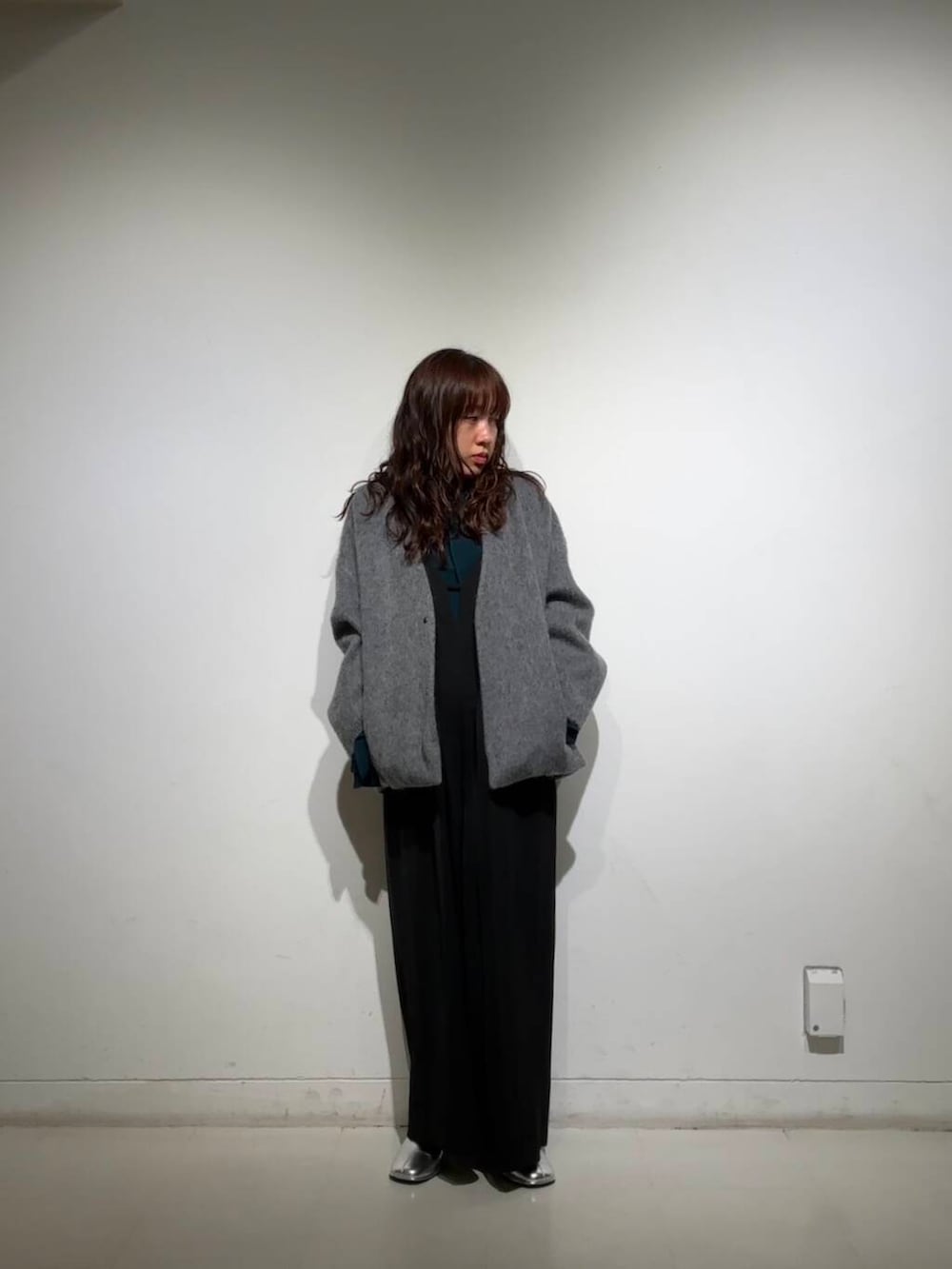 シルバー系のブーツ、グレー系のノーカラージャケット、ブラック系のサロペット/オーバーオールを着用したレディースの冬コーディネートの5枚目の写真