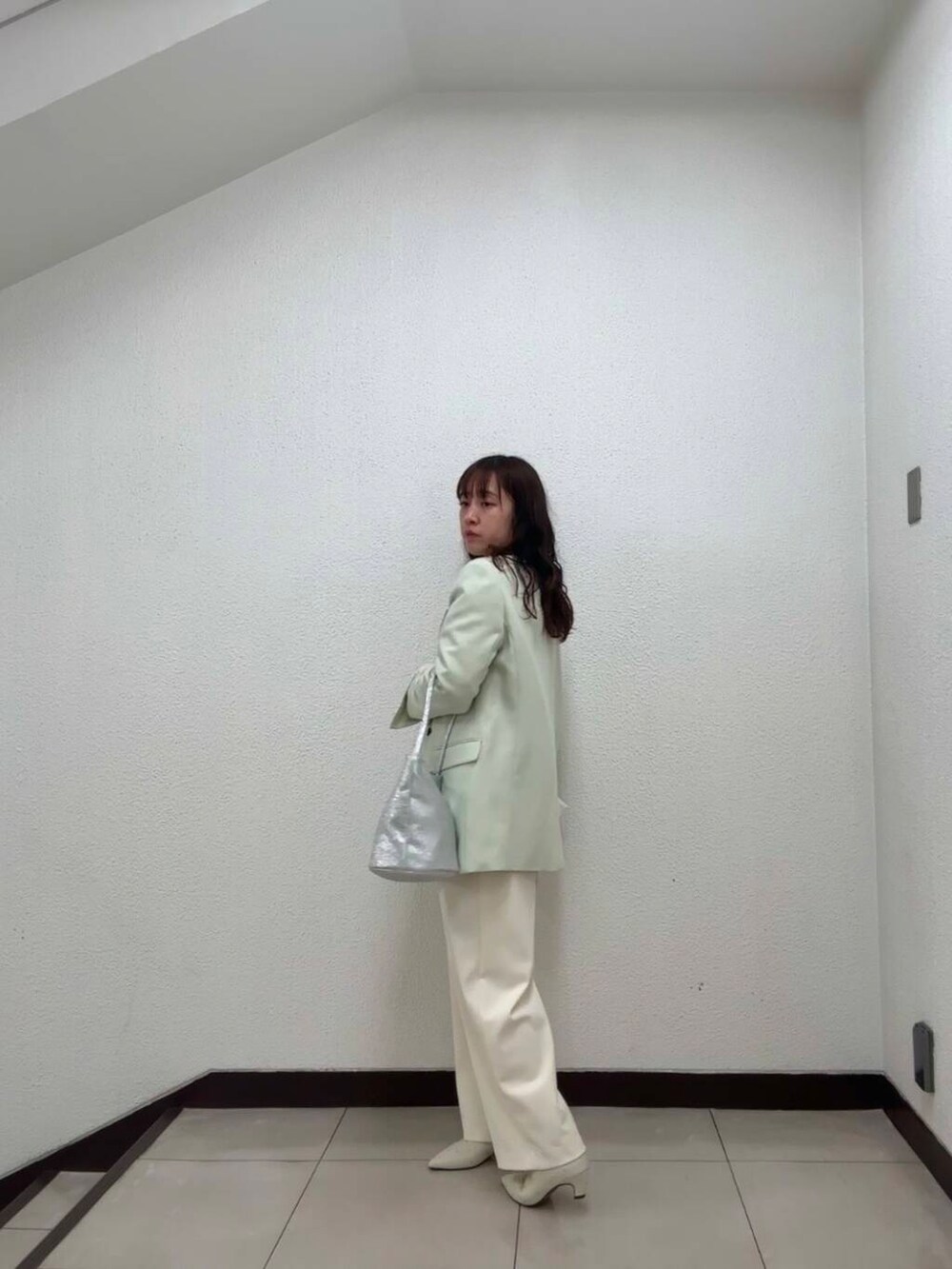 シルバー系のハンドバッグ、ホワイト系のその他パンツ、イエロー系のその他アウターを着用したレディースの冬コーディネートの3枚目の写真