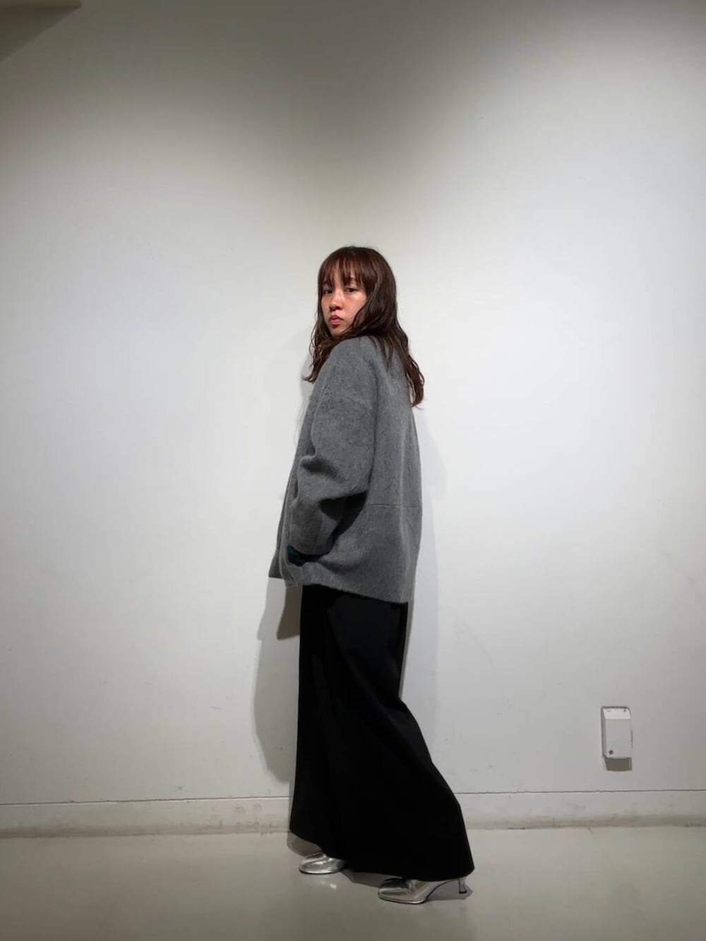 シルバー系のブーツ、グレー系のノーカラージャケット、ブラック系のサロペット/オーバーオールを着用したレディースの冬コーディネートの6枚目の写真