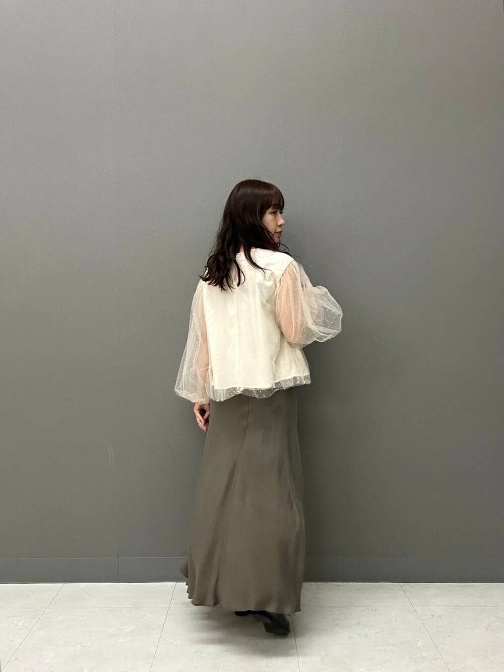 ブラック系のドレスシューズ、グリーン系のスカート、ホワイト系のシャツ/ブラウスを着用したレディースの冬コーディネートの3枚目の写真