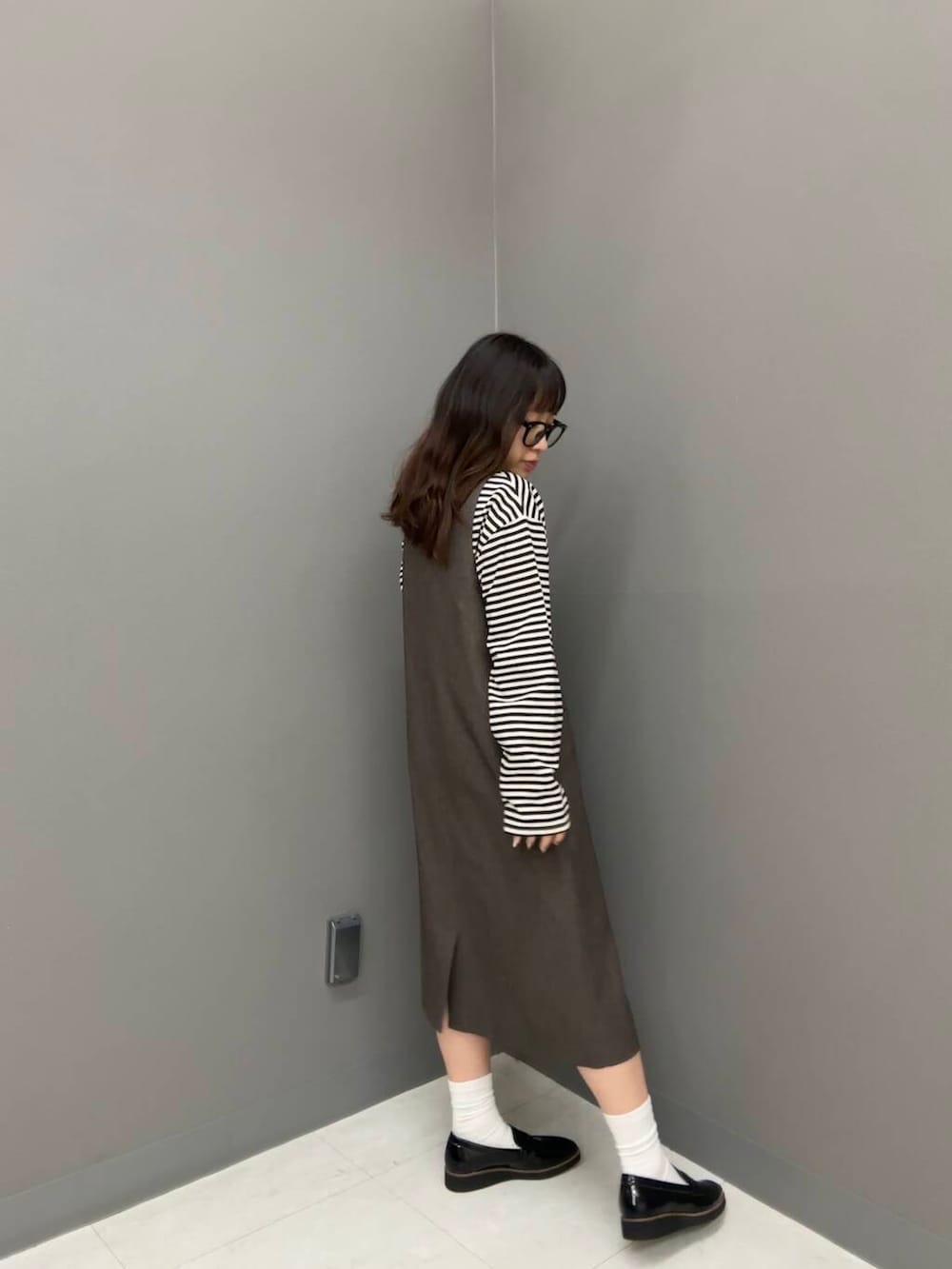 ブラック系のローファー、ホワイト系のTシャツ/カットソー、ブラウン系のワンピースを着用したレディースの秋コーディネートの3枚目の写真