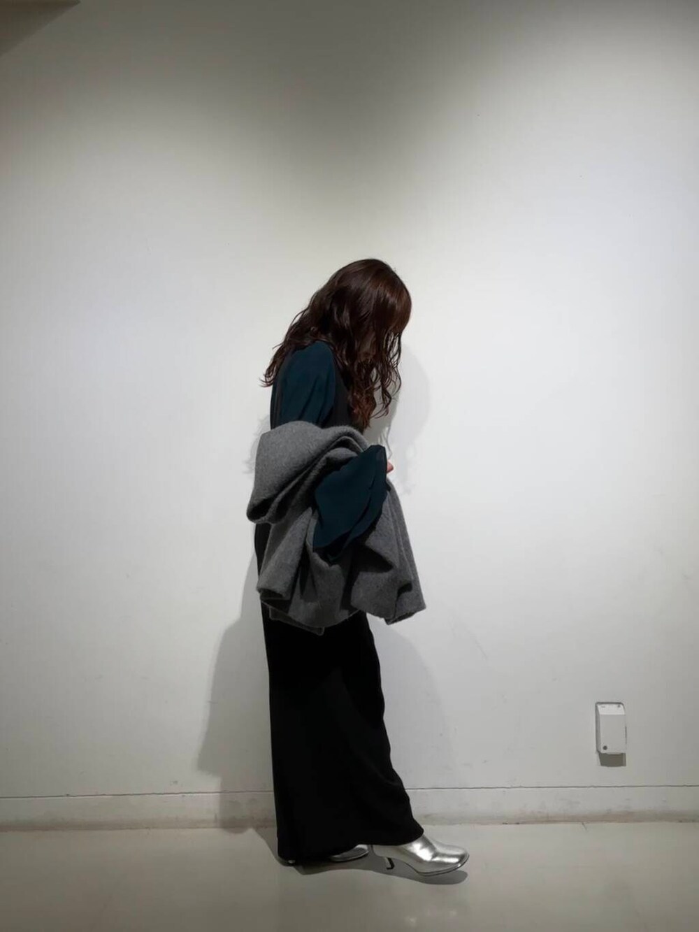 シルバー系のブーツ、グレー系のノーカラージャケット、ブラック系のサロペット/オーバーオールを着用したレディースの冬コーディネートの2枚目の写真