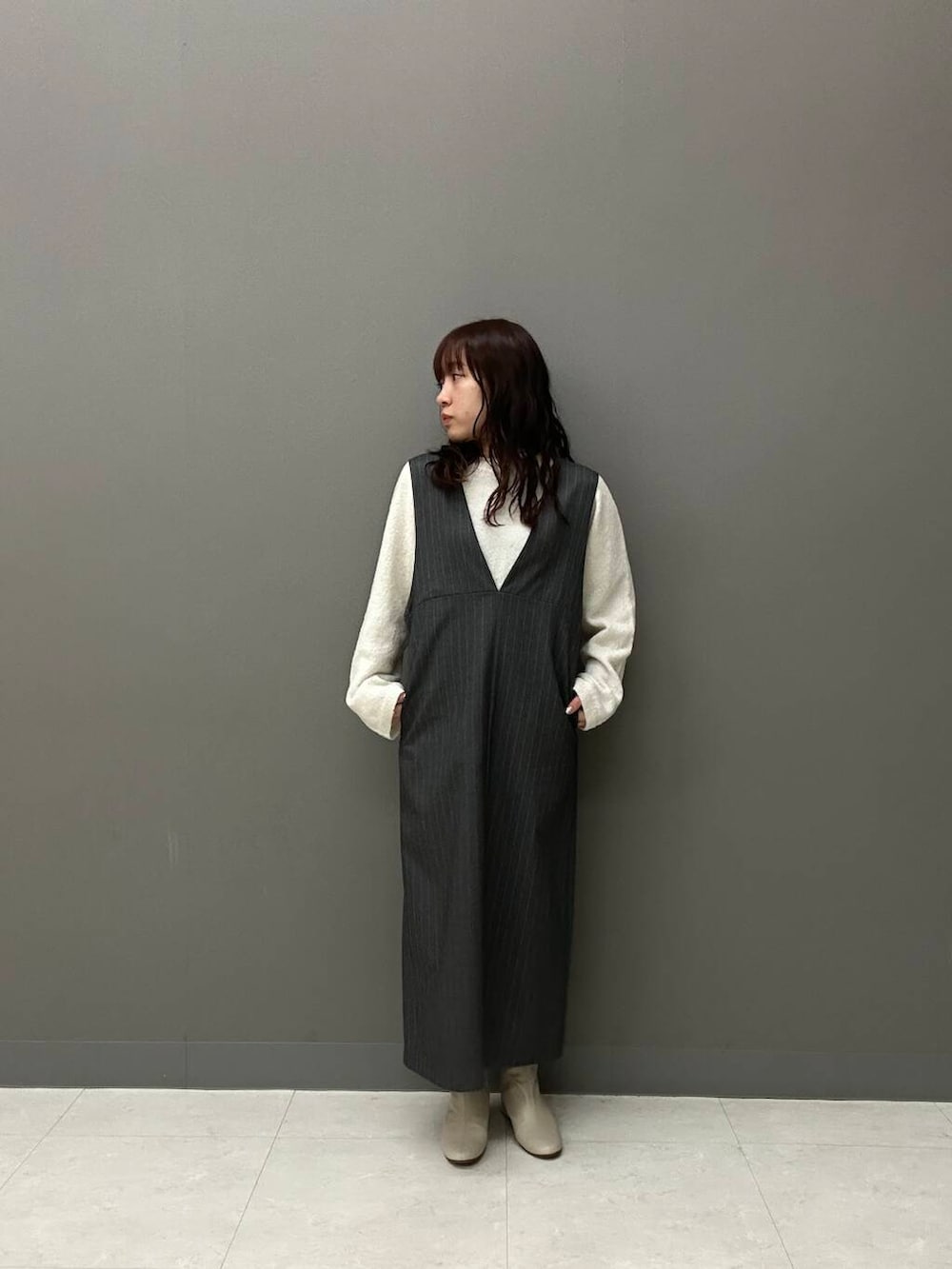 ホワイト系のブーツ、グレー系のワンピース、イエロー系のダウンジャケット/コートを着用したレディースの冬コーディネートの5枚目の写真