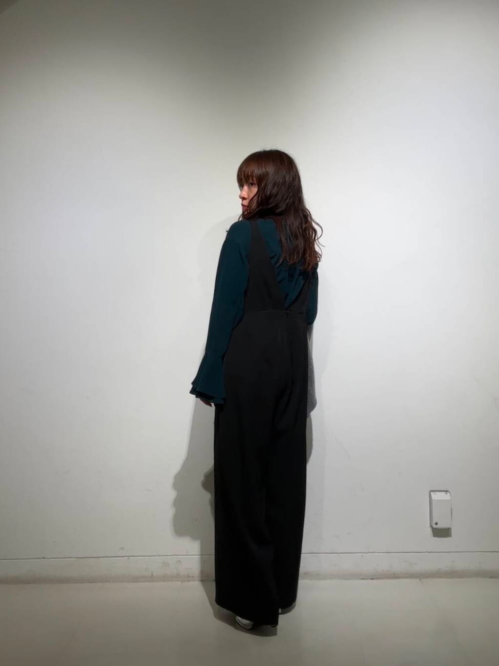 シルバー系のブーツ、グレー系のノーカラージャケット、ブラック系のサロペット/オーバーオールを着用したレディースの冬コーディネートの3枚目の写真