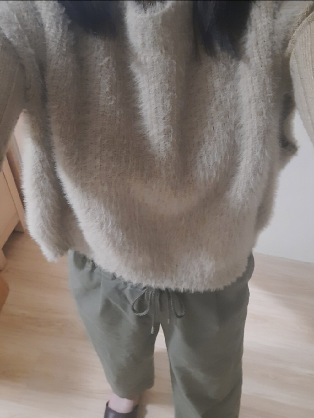 ベージュ系のベストを着用したレディースの冬コーディネートの2枚目の写真