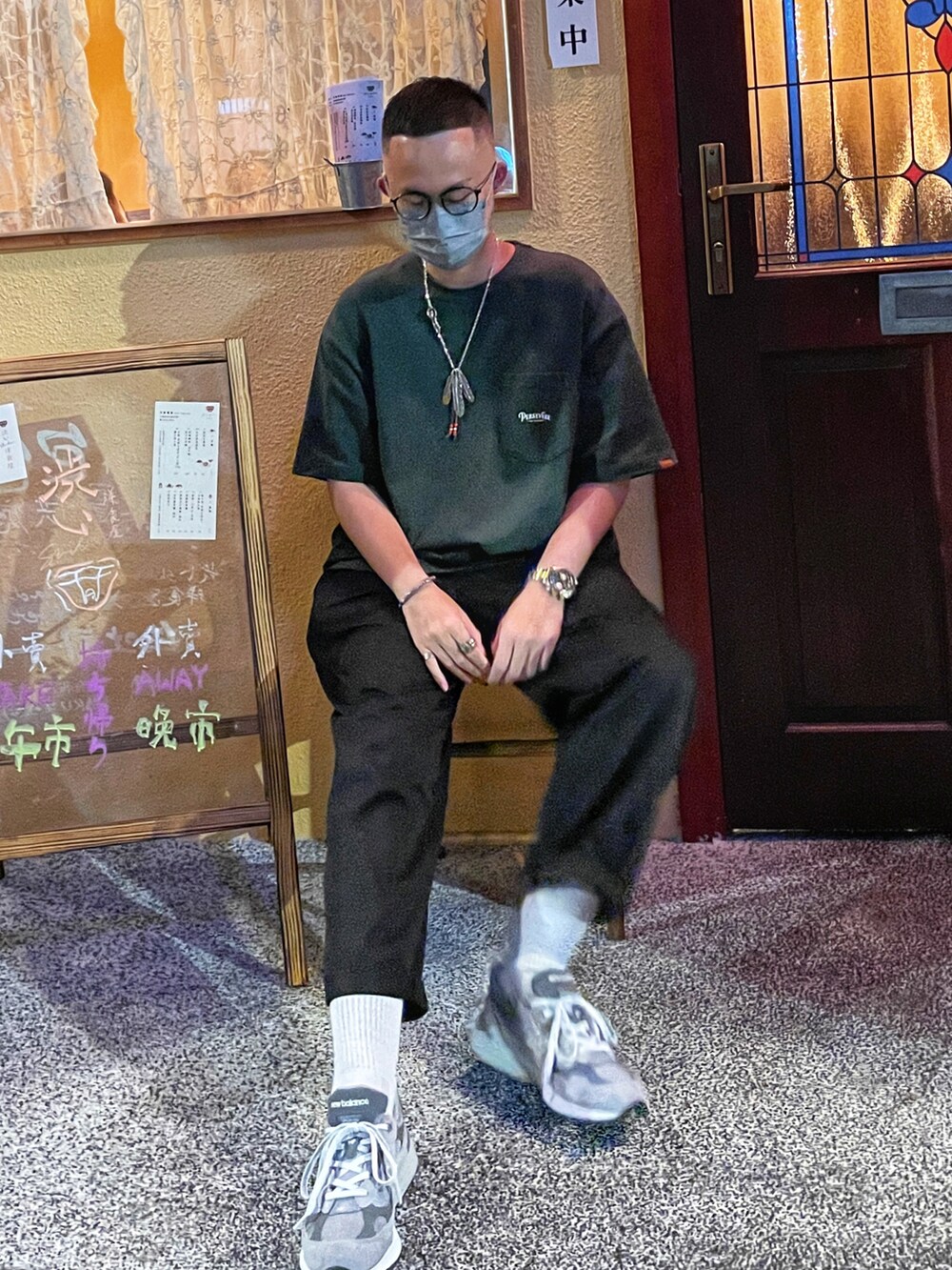 グリーン系のTシャツ/カットソー、ブラック系のチノパンツ、グレー系のスニーカーを着用したメンズの春コーディネートの2枚目の写真