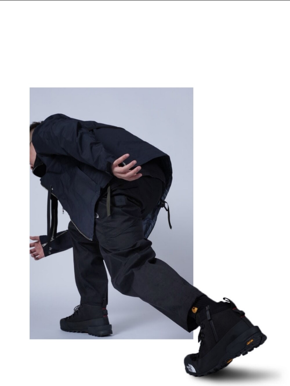 ブラック系のマウンテンパーカー、ブラック系のチノパンツ、ブラック系のその他シューズを着用したメンズの秋コーディネートの2枚目の写真