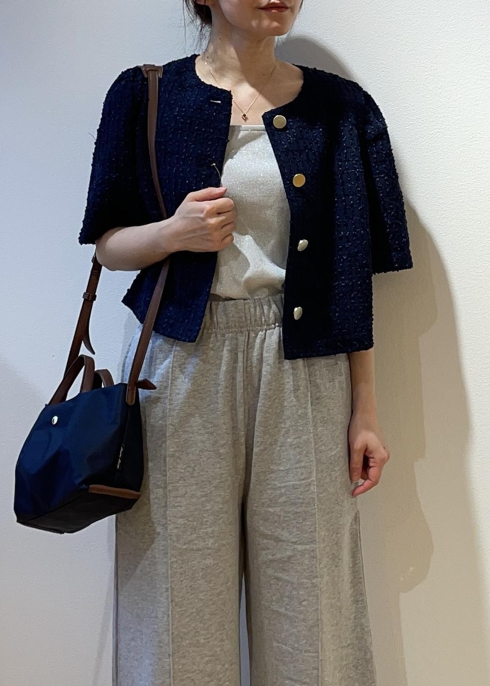 ブルー系のショルダーバッグ、グレー系のその他パンツ、ブルー系のノーカラージャケットを着用したレディースの春コーディネートの4枚目の写真