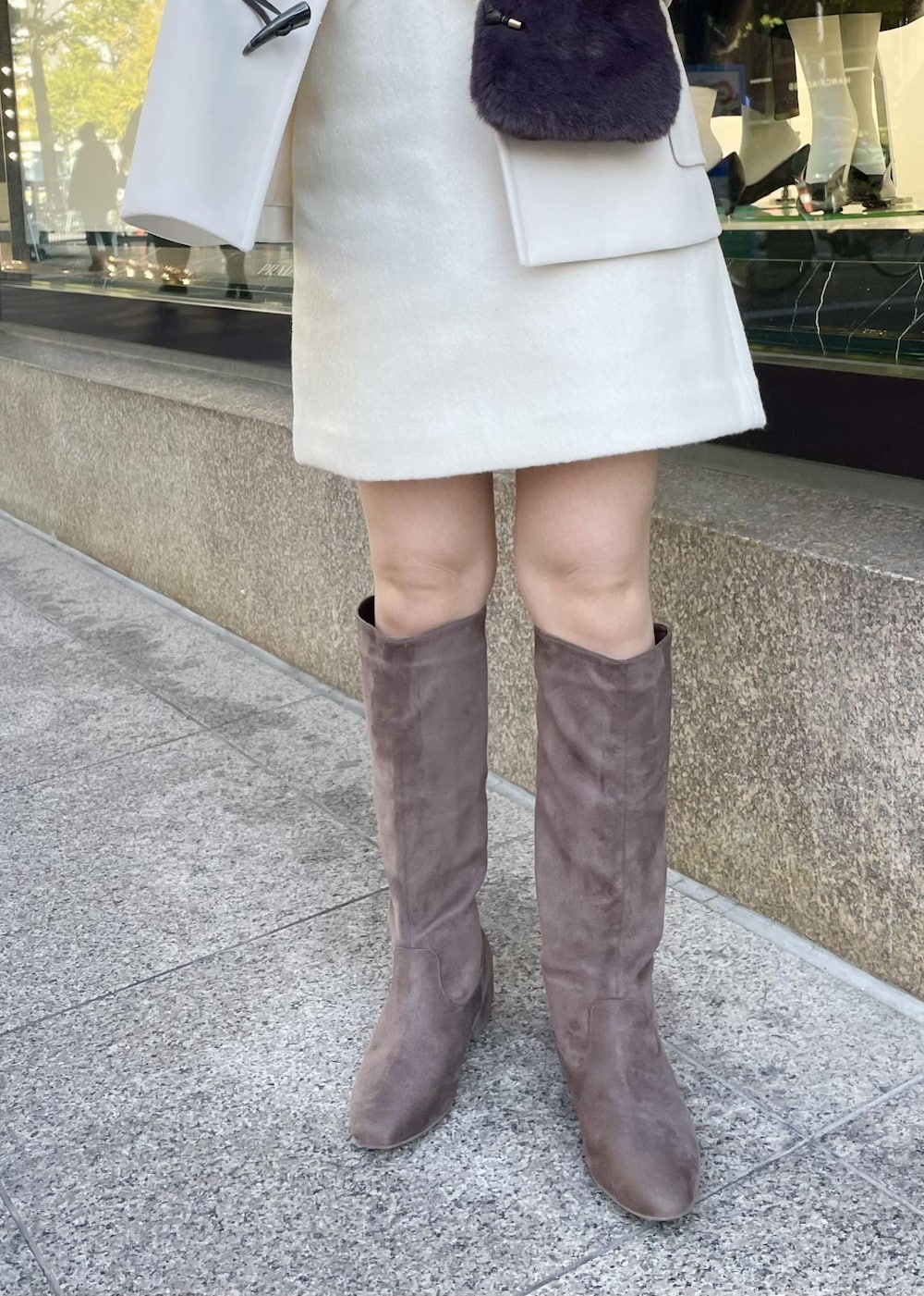 ホワイト系のニット/セーター、ホワイト系のダッフルコート、グレー系のショルダーバッグを着用したレディースの秋コーディネートの4枚目の写真