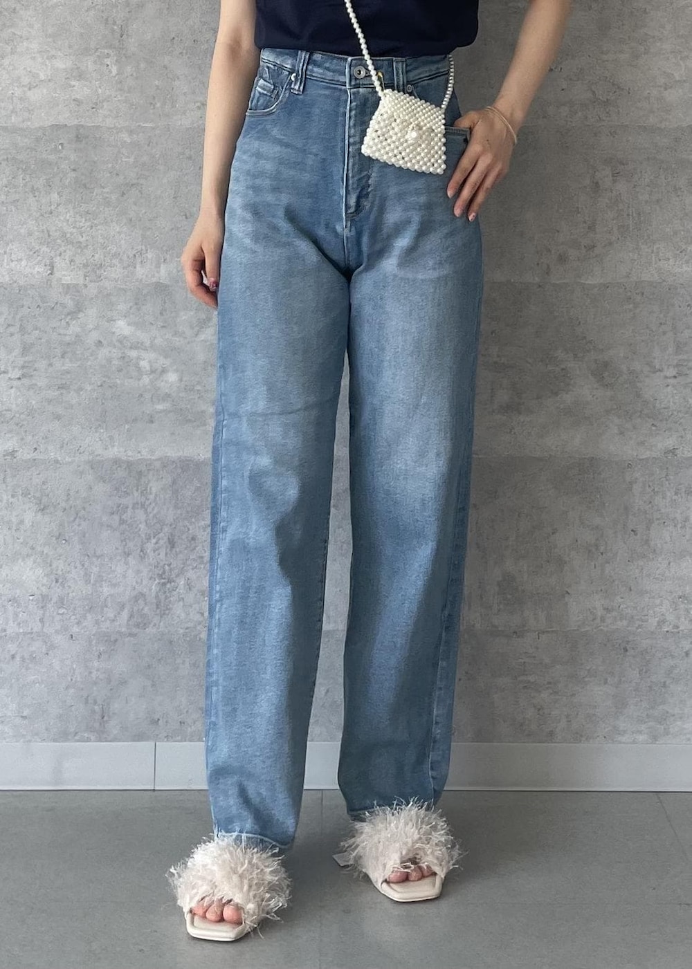 ブルー系のデニムパンツ、ベージュ系のサンダル、ブルー系のTシャツ/カットソーを着用したレディースの秋コーディネートの6枚目の写真