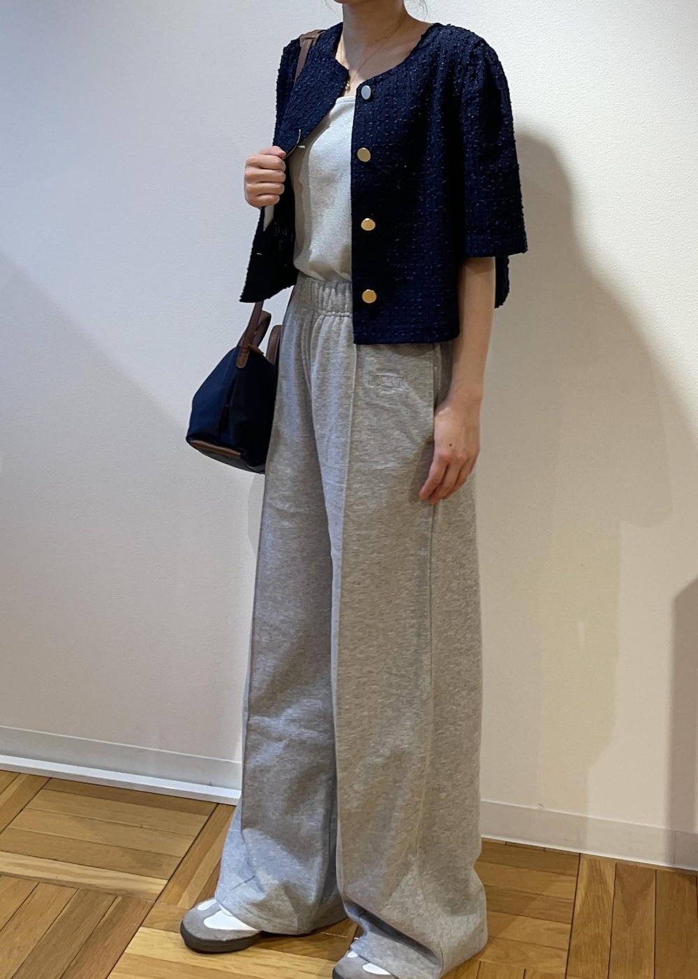 ブルー系のショルダーバッグ、グレー系のその他パンツ、ブルー系のノーカラージャケットを着用したレディースの春コーディネートの3枚目の写真