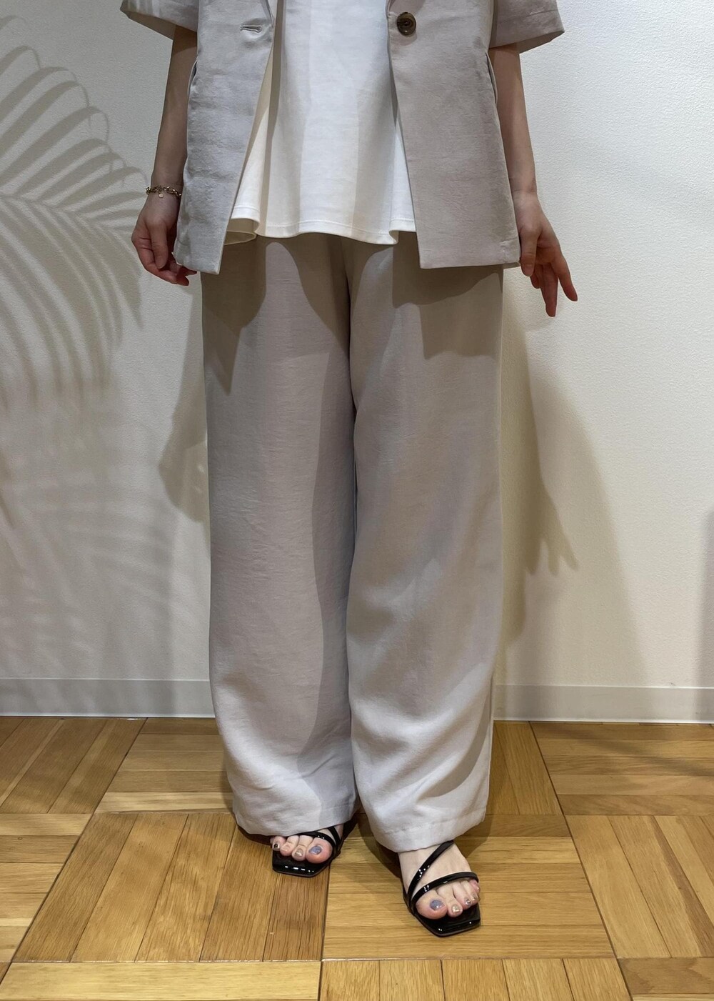 ベージュ系のテーラードジャケット、ブラック系のサンダル、ベージュ系のその他パンツを着用したレディースの夏コーディネートの7枚目の写真