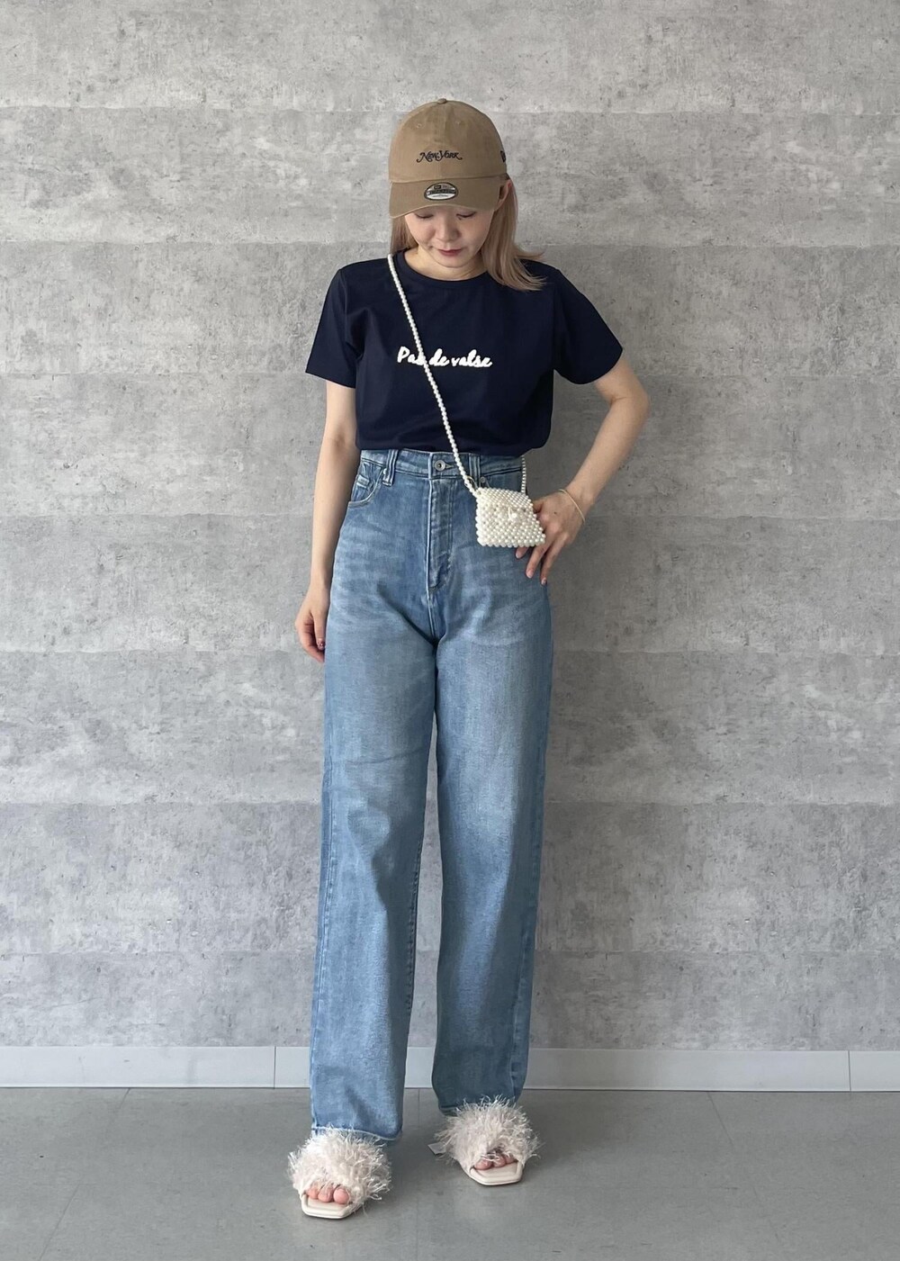 ブルー系のデニムパンツ、ベージュ系のサンダル、ブルー系のTシャツ/カットソーを着用したレディースの秋コーディネートの2枚目の写真