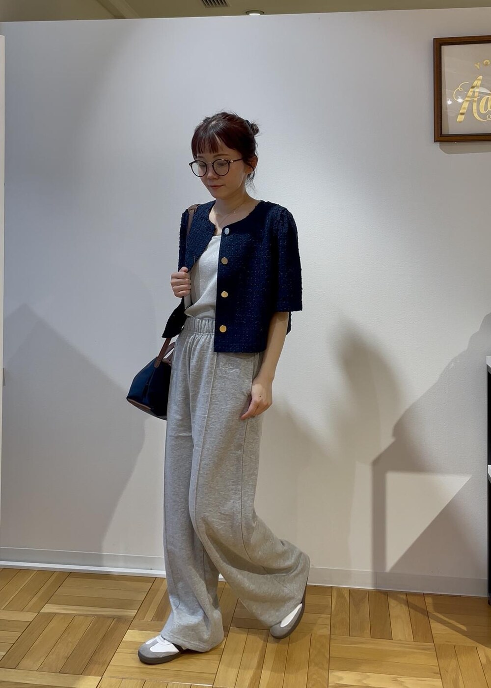 ブルー系のショルダーバッグ、グレー系のその他パンツ、ブルー系のノーカラージャケットを着用したレディースの春コーディネートの2枚目の写真