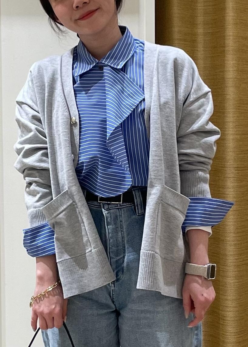 ブルー系のシャツ/ブラウス、グレー系のカーディガン/ボレロ、ブラック系のハンドバッグを着用したレディースの春コーディネートの6枚目の写真