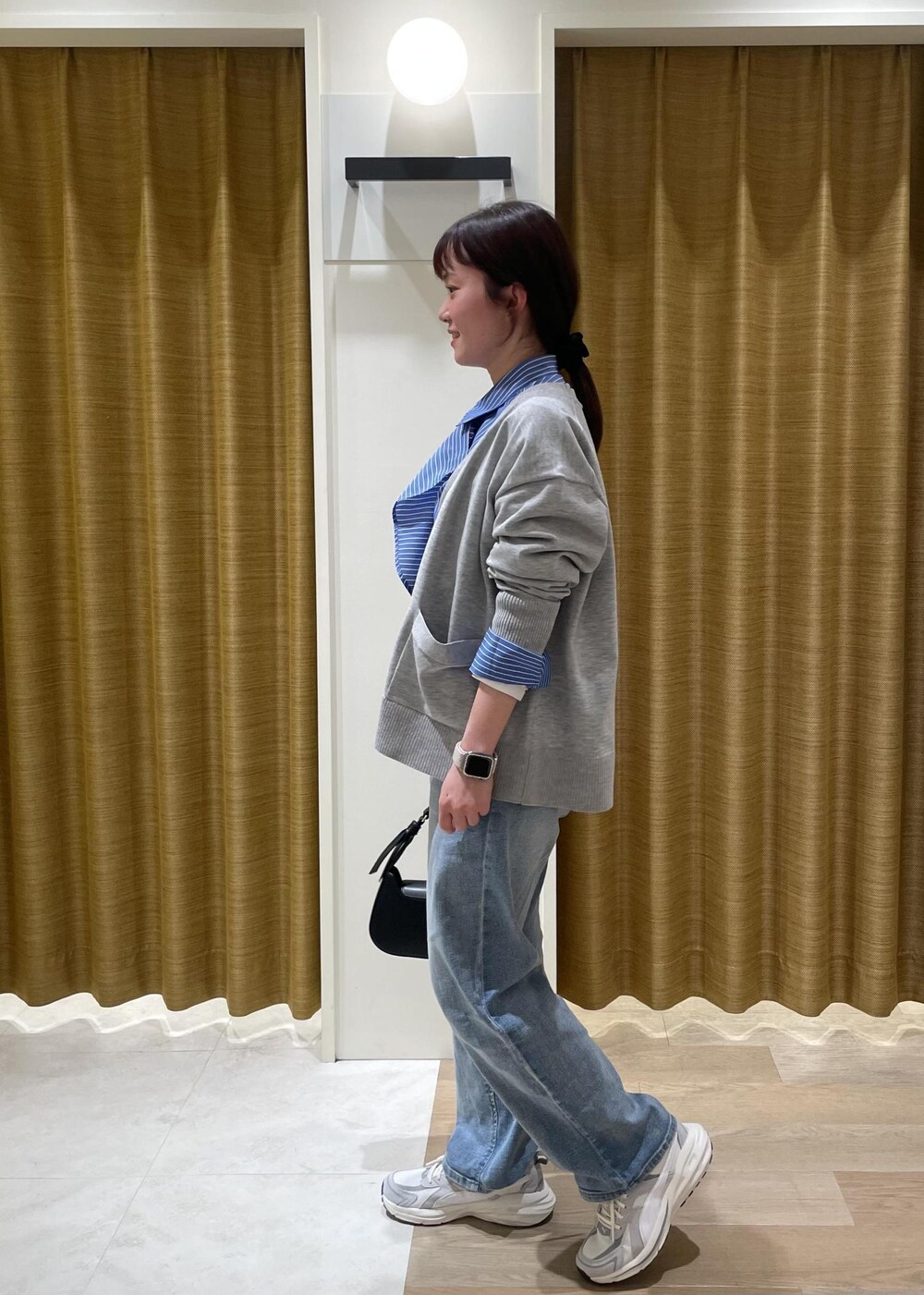 ブルー系のシャツ/ブラウス、グレー系のカーディガン/ボレロ、ブラック系のハンドバッグを着用したレディースの春コーディネートの5枚目の写真