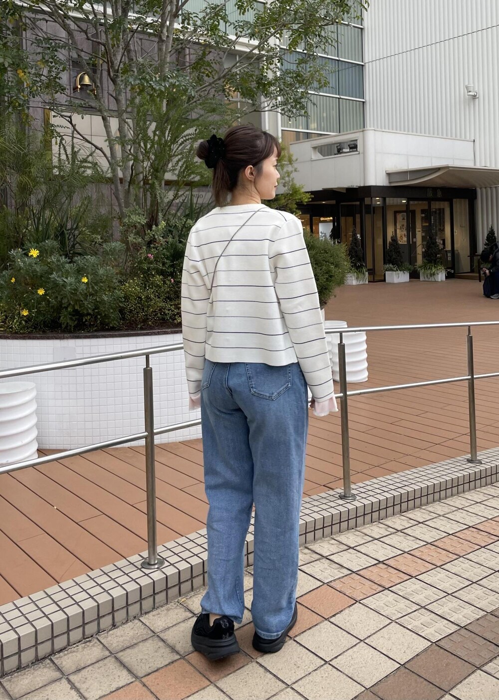 ブラック系のショルダーバッグ、ピンク系のニット/セーター、ホワイト系のカーディガン/ボレロを着用したレディースの冬コーディネートの4枚目の写真